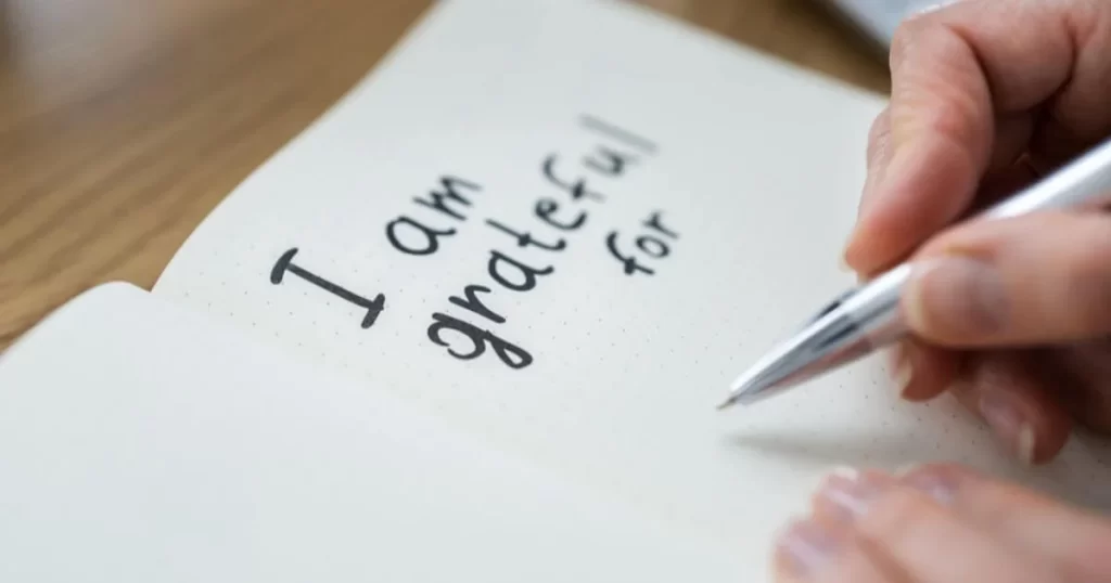 A journal that says "I am grateful for," with a pen about to write