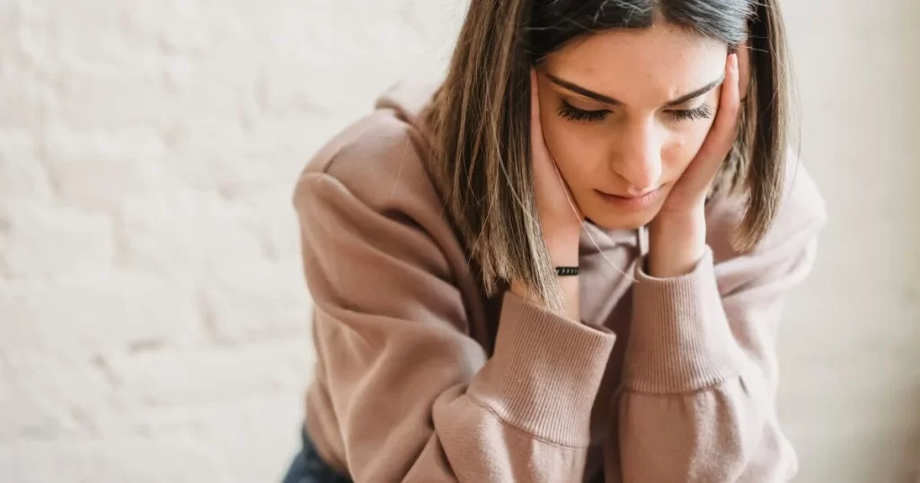 A woman holding her head in her hands